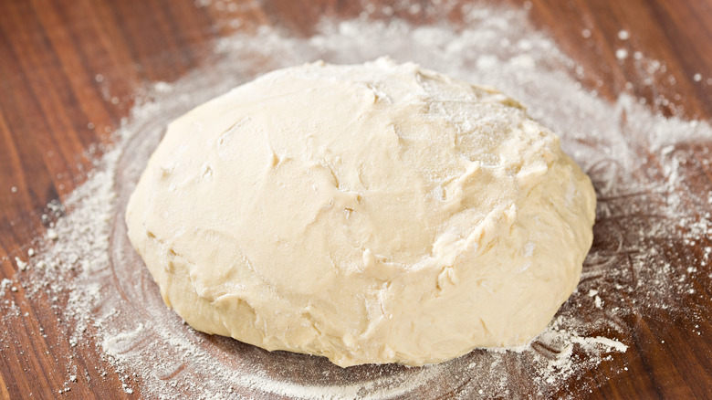 Raw pizza dough on flour