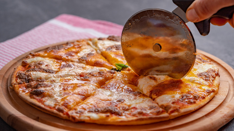 Slicing a homemade margherita pizza