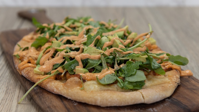 Drizzle and arugula on pizza