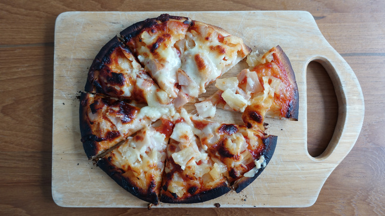 Burnt pizza on cutting board