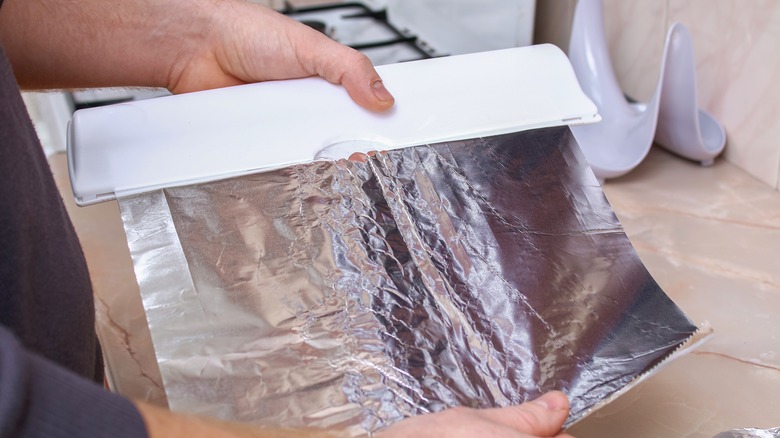 Person tearing tin foil