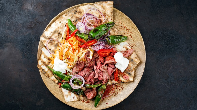 Pita with coleslaw and other toppings on table