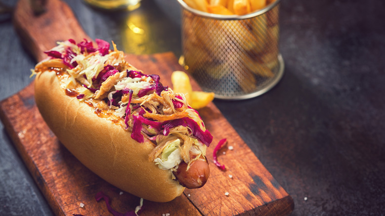 Hot dog with coleslaw and other toppings on board