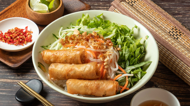 Spring rolls with coleslaw and greens in a bowl