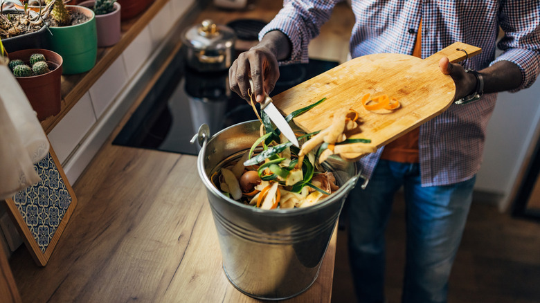 person scraping peels for composting