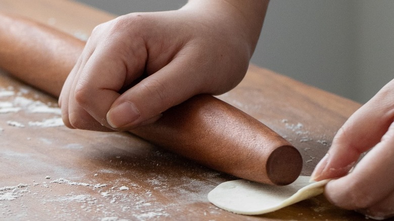 Wooden rolling pin rolling dough