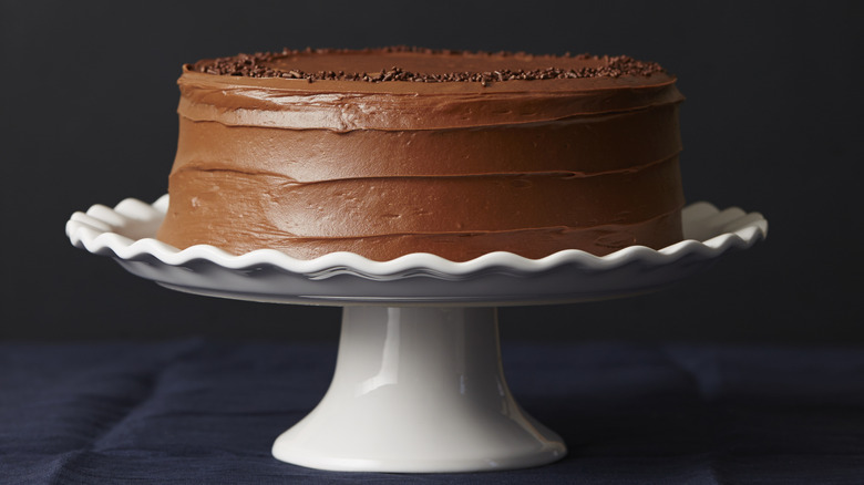 Chocolate cake on white scalloped cake stand