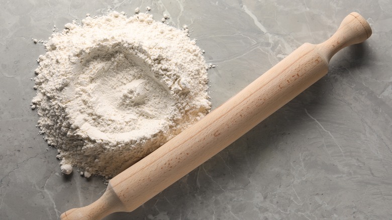 Rolling pin sitting next to flour