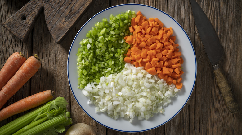 Diced fresh carrots, onion, and celery on a plate