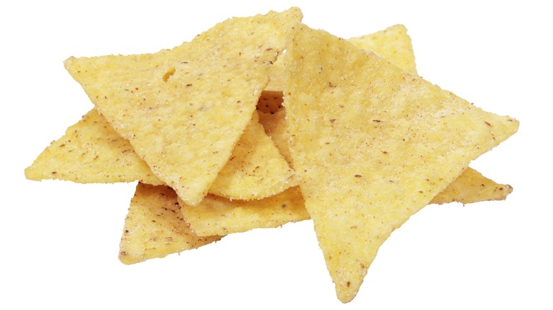 Yellow tortilla chips against white background