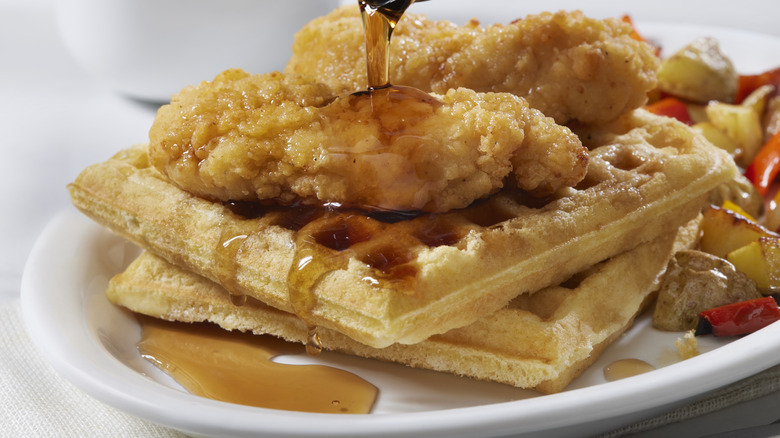 Fried chicken and syrup sit atop a buttermilk waffle.