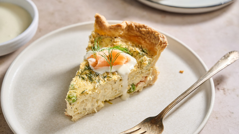 Quiche slice on plate with fresh dill