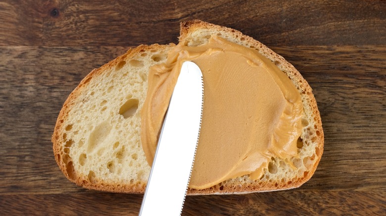 knife spreading maple butter onto slice of bread