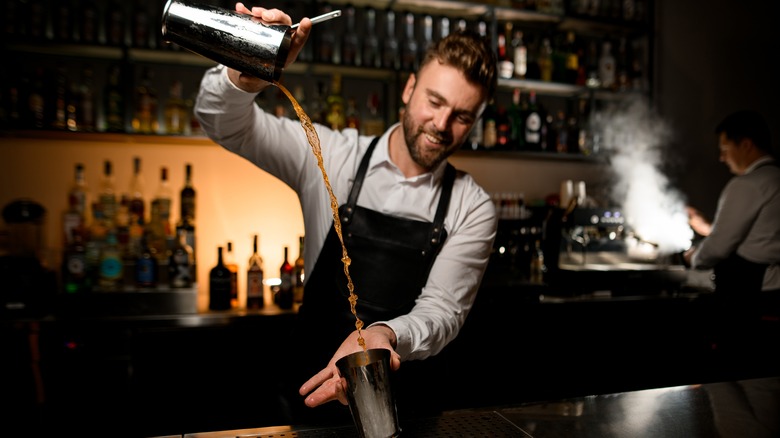 Bartender pouring drink from shaker