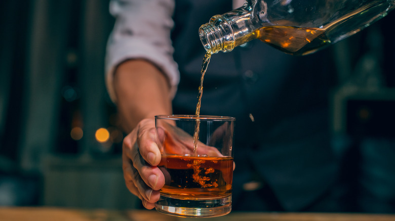 Bartender pouring drink into glass