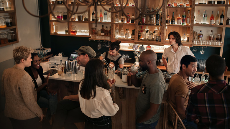 Two bartenders serving guests