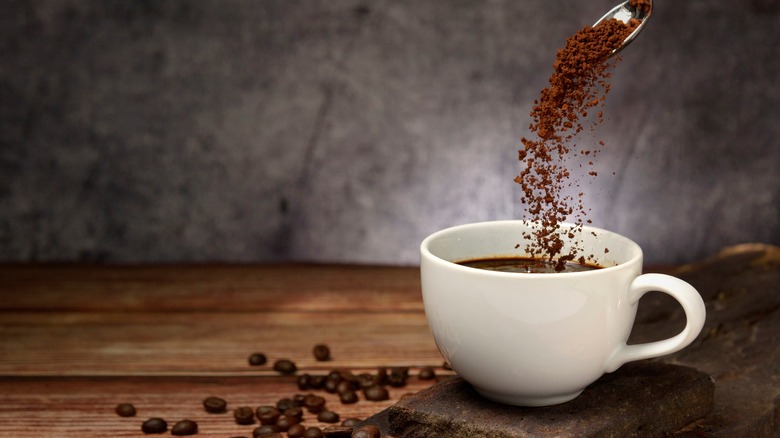 Pouring instant coffee into cup