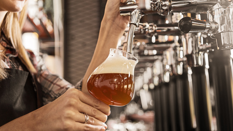 Person pouring beer from spout