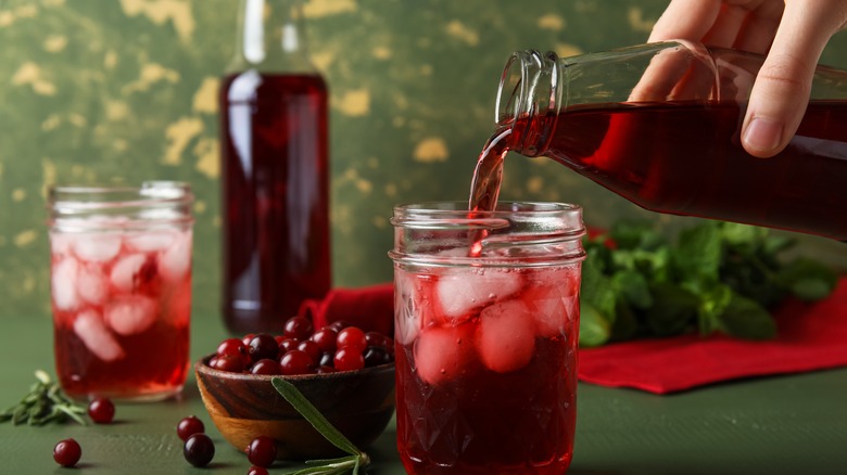 Hand pouring cranberry juice