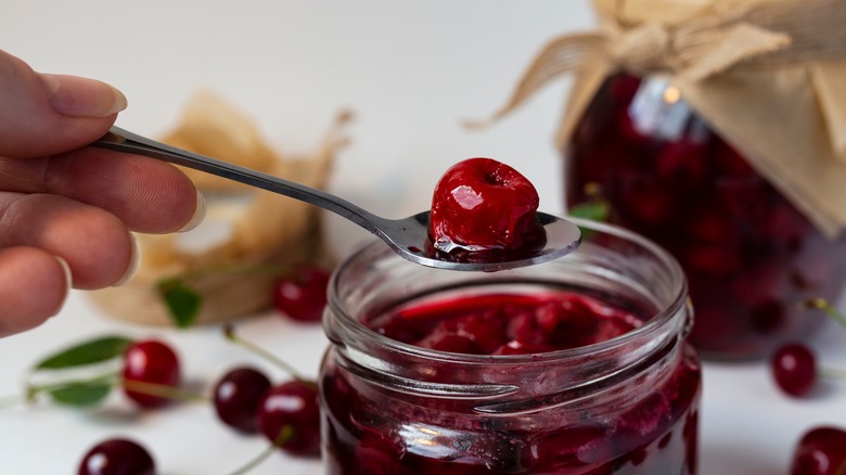 jar of cherries with hand