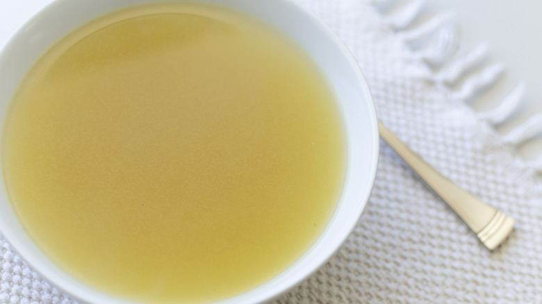 Chicken broth in white bowl on table