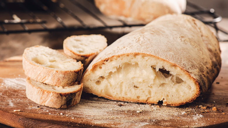 Ciabatta bread sliced on wooden cutting board