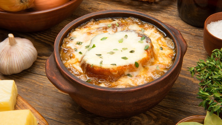 French onion soup in brown bowl on wooden table