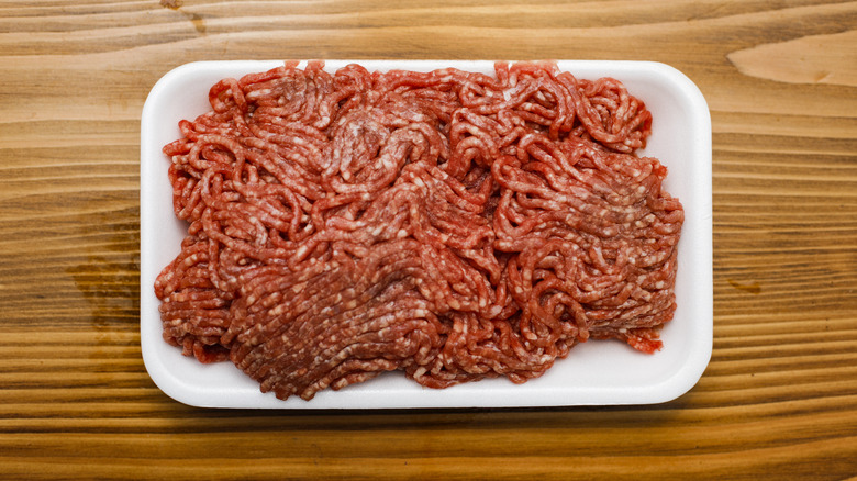 Ground beef on styrofoam tray on wooden table