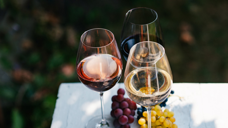 Red, white, and rose wine outside on table with tablecloth