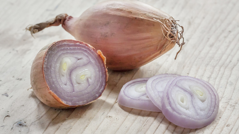 Two shallots with shallot slices on table