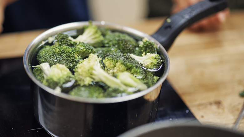 broccoli florets boiling in saucepan 