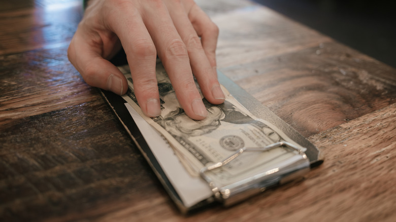 Close-up of hand leaving cash at restaurant