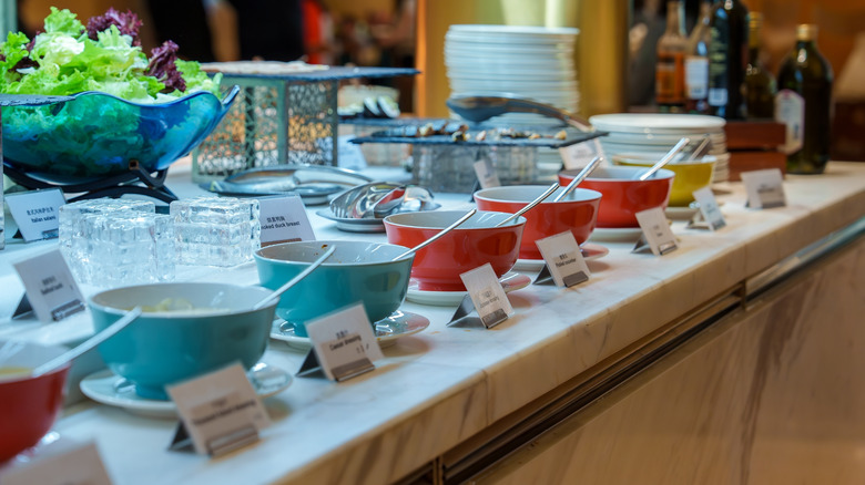 variety of colorful bowls and plates with sauces and condiments on a marble countertop