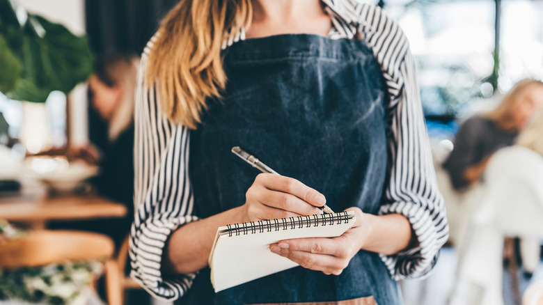 waitress writing on notepad