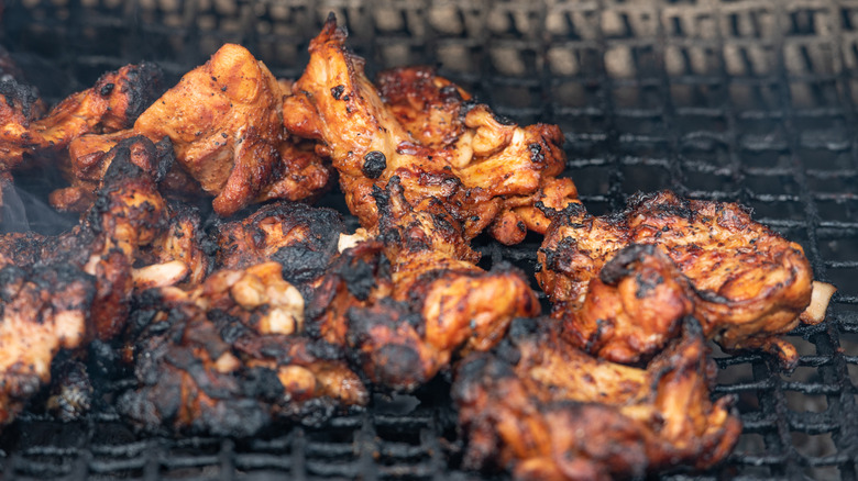 Jerk chicken cooking in a traditional oil drum barbecue