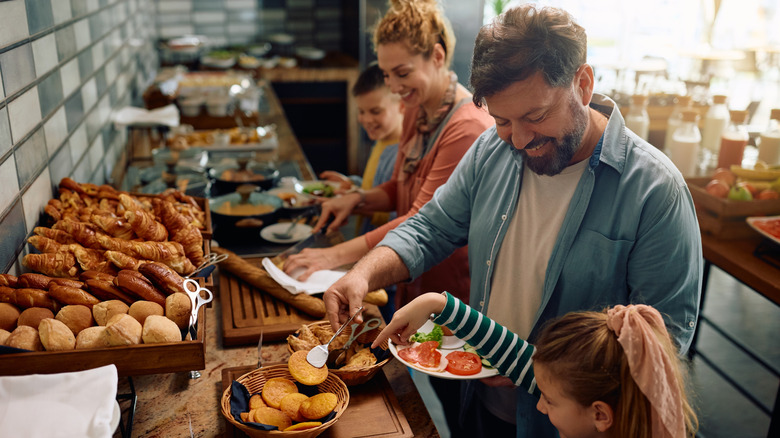 Happy family enjoying in buffet breakfast in a hotel