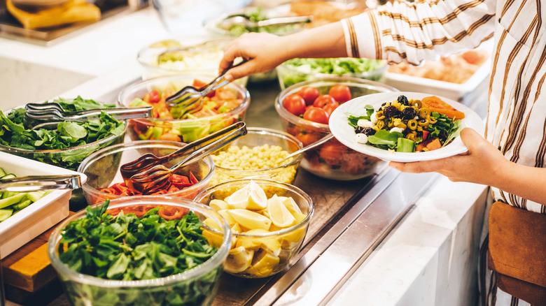 Woman taking food from a buffet line