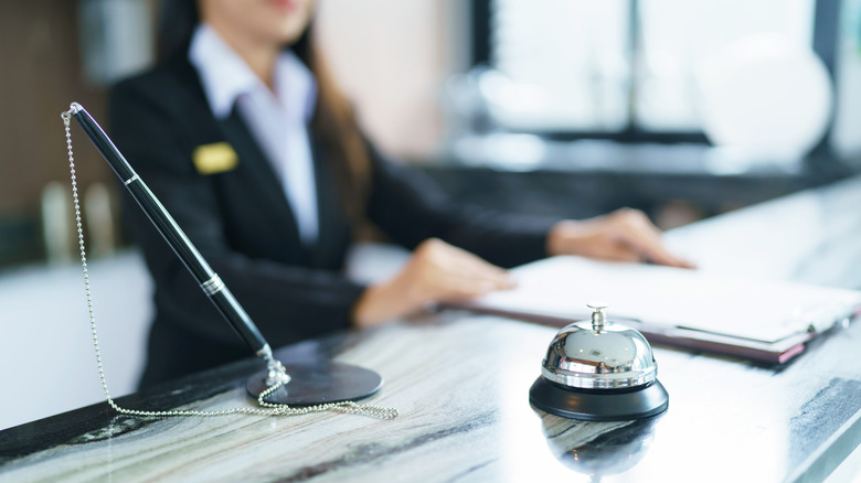 Hotel receptionist in uniform at desk in lobby