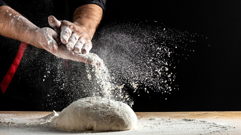 Man flouring a dough ball