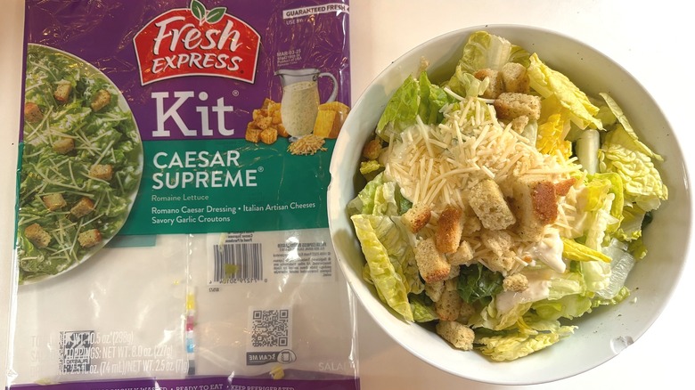 Fresh Express Caesar Supreme Salad Kit in white bowl next to package on white table
