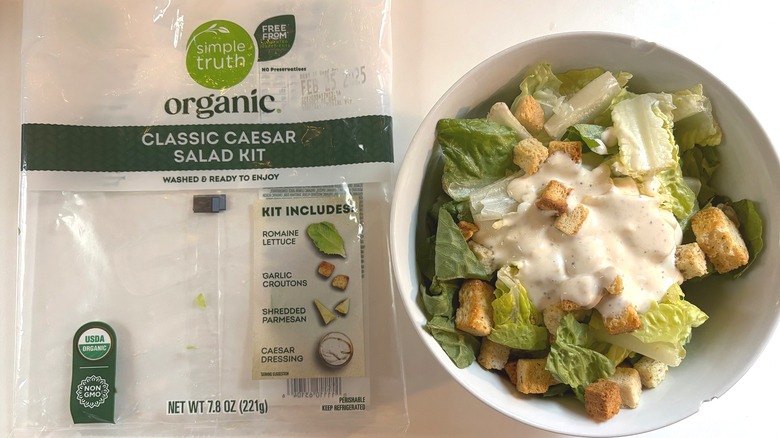 Simple Truth Organic Classic Caesar Salad Kit in white bowl next to package on white table