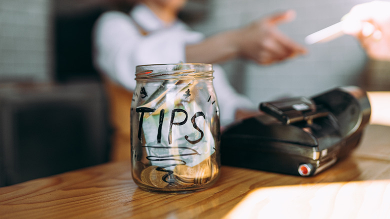 tip jar on counter with cash