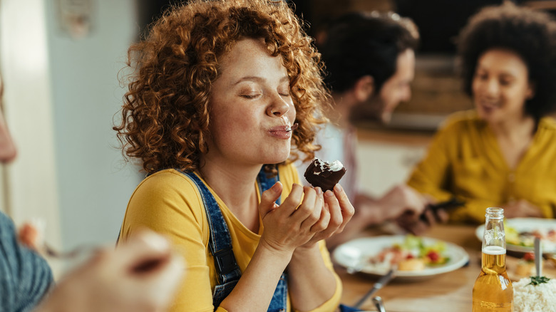 woman eyes closed enjoying food