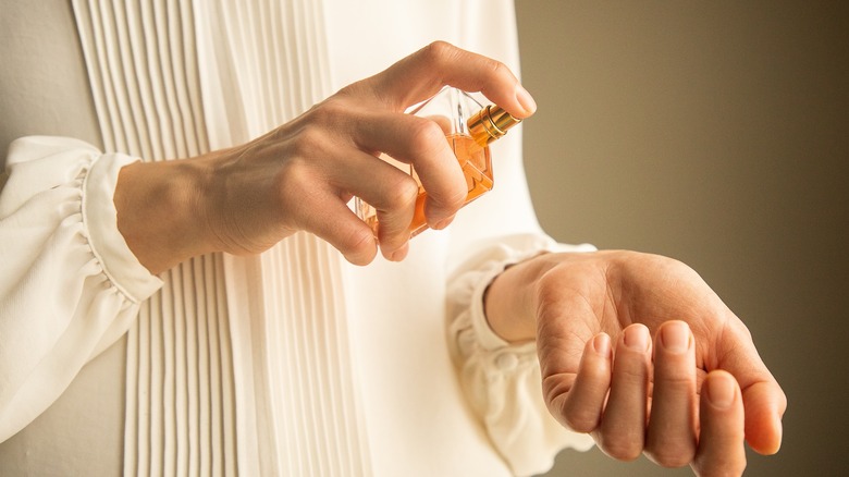 Woman applying perfume