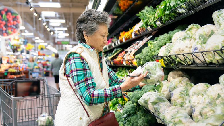 Person buying cauliflower in store