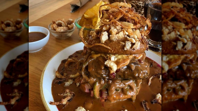 Burger covered with sauce and fried onions 