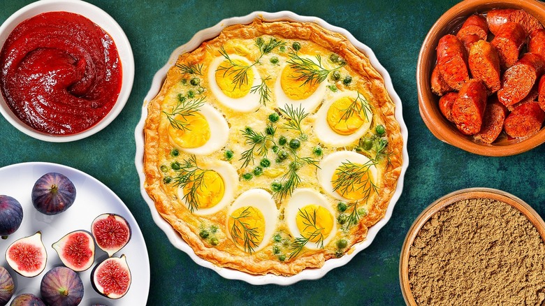 Quiche on green background with different ingredients