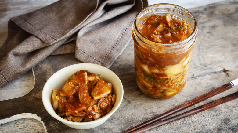 Bowl and jar of kimchi with wooden chopsticks