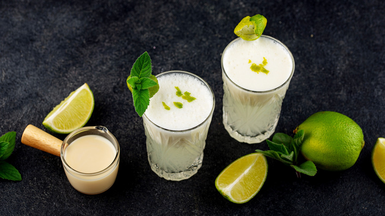 two glasses of limonada suíça surrounded by ingredients