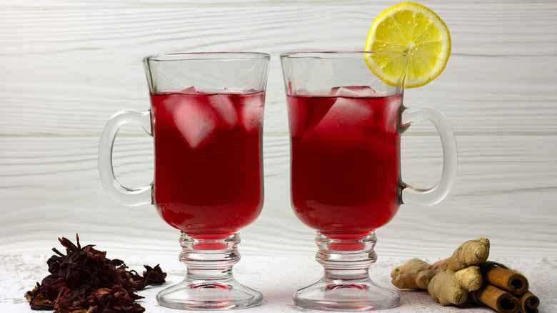 two glasses of zobo with lemon slice, ginger, and cinnamon